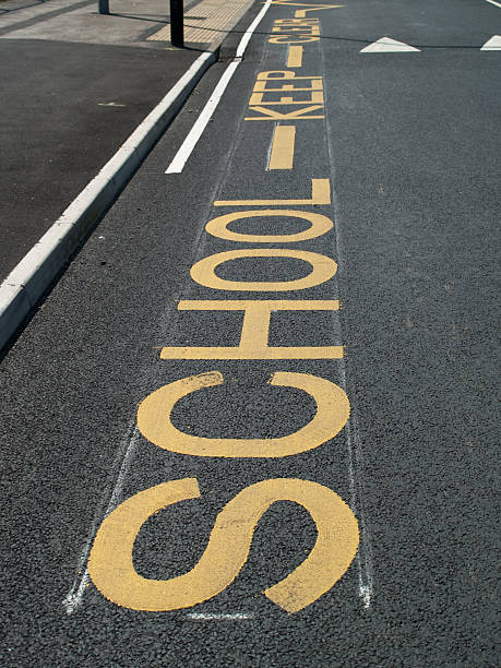 School Keep Clear markings in road outside UK school stock photo