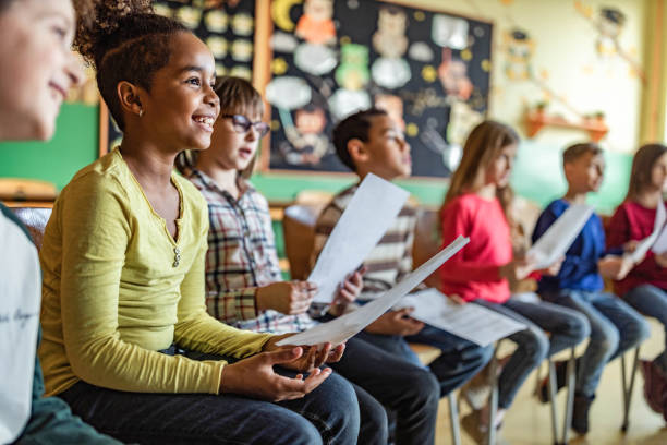 School kids practicing with sheet music on a class at school. stock photo