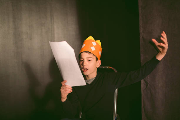 School Play Rehearsal 11 years old boy enjoying drama club rehearsal. Holding script and reading. young male actors stock pictures, royalty-free photos & images