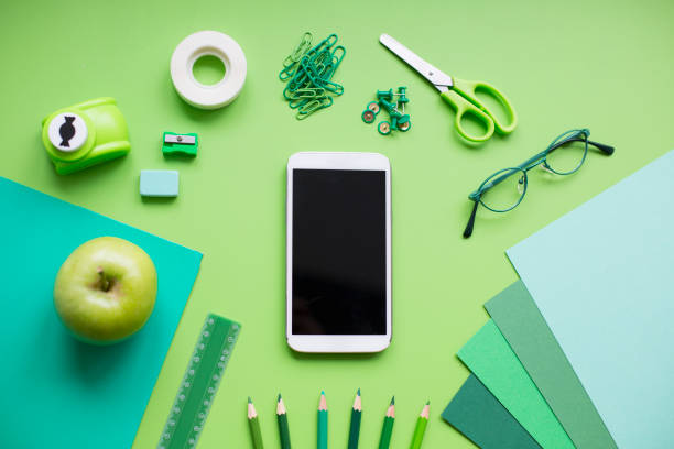 School supplies on green background School supplies on green background. smart phone green background stock pictures, royalty-free photos & images