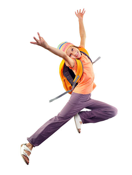 schoolgirl with backpack and a cap jumping stock photo