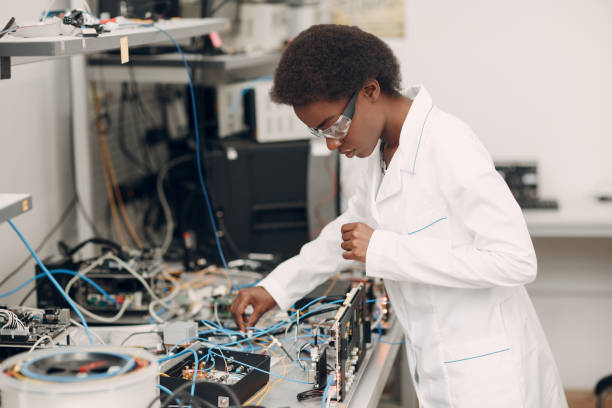 Scientist african american woman working in laboratory with electronic instruments Scientist african american woman working in laboratory with electronic tech. Research and development of electronic devices by color black woman. Electrical Engineering stock pictures, royalty-free photos & images
