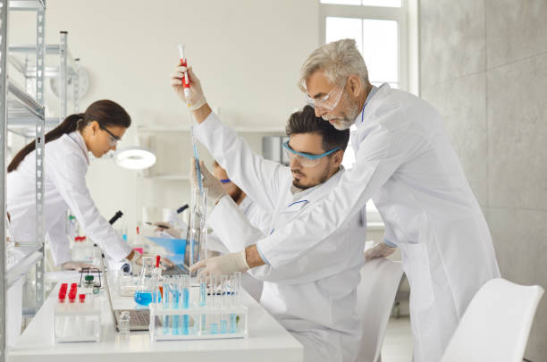 Scientist group working with many lab equipment for research at laboratory stock photo