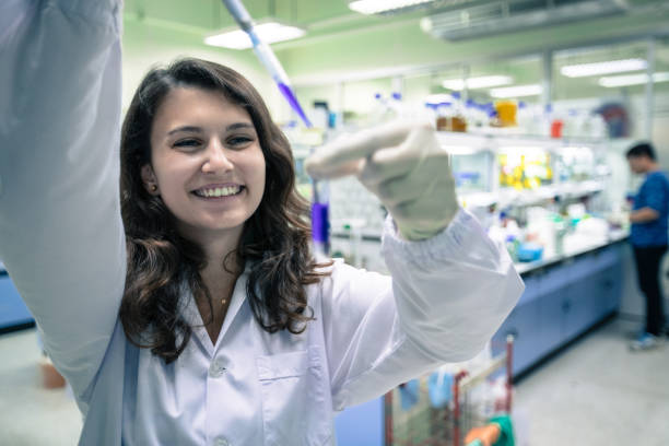 Scientist with pipette and test tube, examining samples and liquid in laboratory stock photo