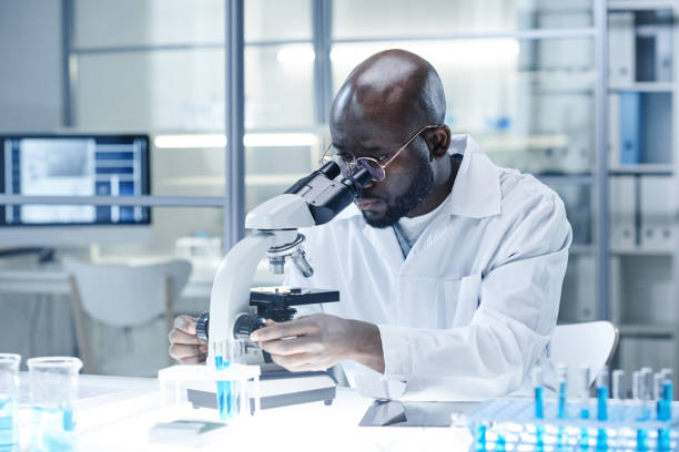 Scientist working with microscope at the lab stock photo