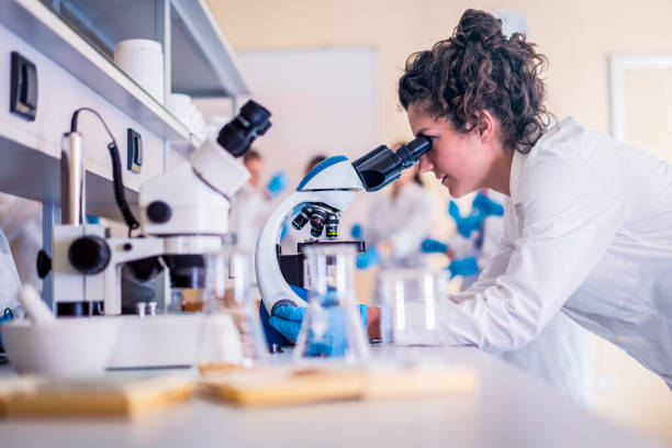 Scientists in laboratory working on research Scientist in lab doing research and using lab machines, test tubes, microscope and every laboratory equipment biotechnology stock pictures, royalty-free photos & images
