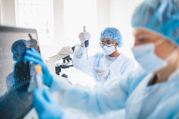para ilmuwan mengenakan pakaian pelindung penuh bekerja di laboratorium - riset medis potret stok, foto, & gambar bebas royalti