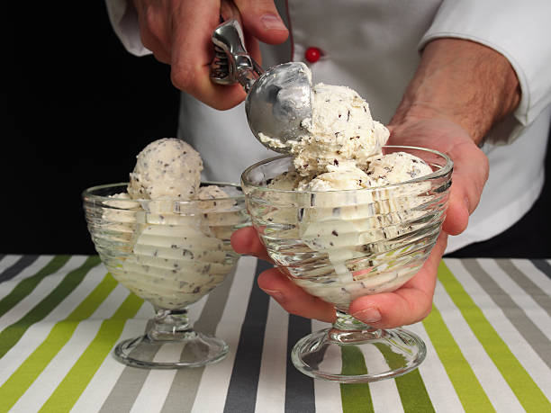Scooping ice cream into bowl stock photo