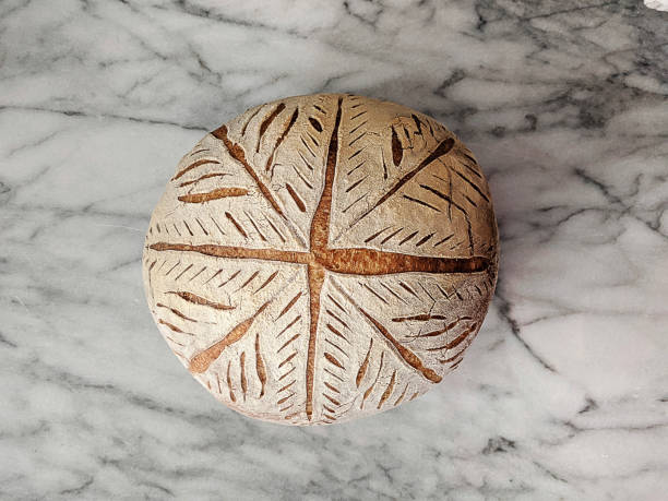 Scored Sourdough Bread A round loaf of sourdough bread with detailed scoring on a white marble cutting board artisanal food and drink stock pictures, royalty-free photos & images