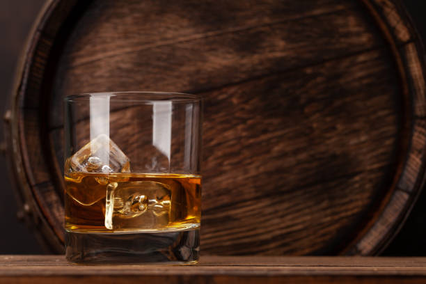 Scotch whiskey glass and old barrel Scotch whiskey glass and old wooden barrel. With copy space rum stock pictures, royalty-free photos & images