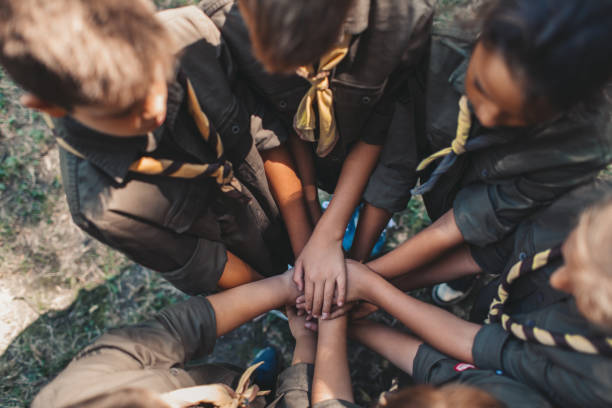 Scouts Unity Group of young scouts joining hands together, showing their unity. scout camp stock pictures, royalty-free photos & images