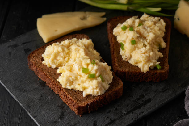 Scrambled eggs with green onion with gluten free bread on table stock photo