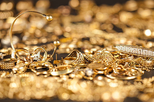 Scrap Gold Collection Table of scrap gold being inspected.Focal point on the two bracelets. gold jewelry stock pictures, royalty-free photos & images