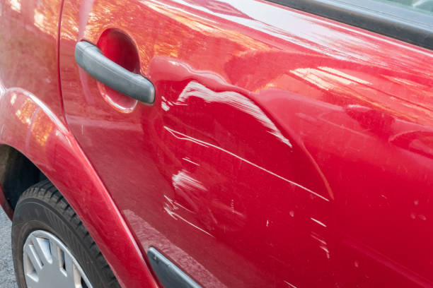 Scratches on the red car Scratches on the side door of the red car. Collision or accident. dented stock pictures, royalty-free photos & images