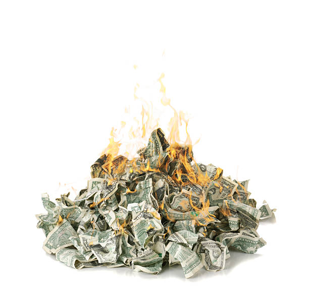 Screwed up dollar notes in a pile on fire A burning pile of US one dollar bills. burning stock pictures, royalty-free photos & images