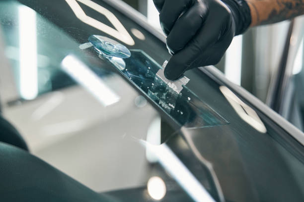 Scrubbing off excess glue to repair cracked car windshield. Final remove stock photo