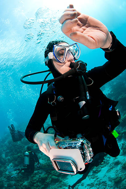 Scuba diver looking at watch during safety stop stock photo