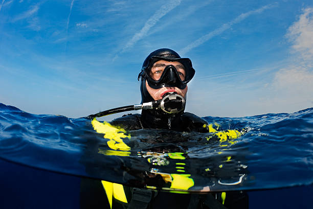 Scuba Diver Scuba diver on the sea surface ready to decend. deep sea diving stock pictures, royalty-free photos & images