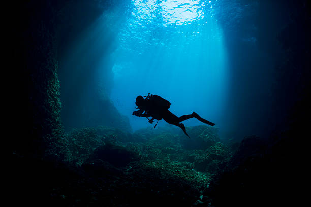 Scuba Diver Silhouette Scuba Diver Silhouette. Underwater scene of blue cave. UNDERWATER Photographed on canon 5d mk2. deep sea diving stock pictures, royalty-free photos & images