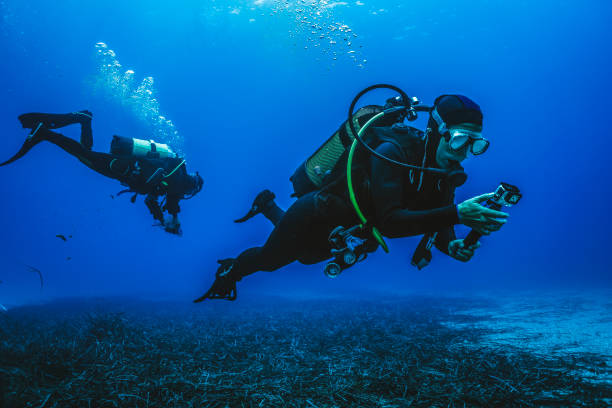 Scuba divers explore underwater reefs He films it on his underwater camera aqualung diving equipment photos stock pictures, royalty-free photos & images