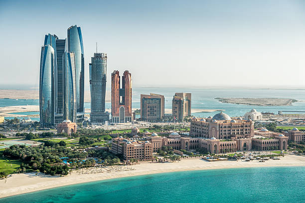 Sea and skyscrapers in Abu Dhabi Helicopter point of view of sea and skyscrapers in Corniche bay in Abu Dhabi, UAE. Turquoise water and blue sky combined with building exterior. united arab emirates stock pictures, royalty-free photos & images