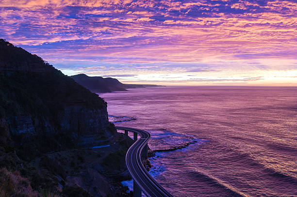 Sea Cliff Bridge on sunrise  in purple and pink light stock photo