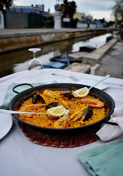 Seafood paella with glass of wine in seaside cafe,Spain stock photo