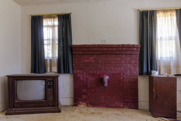 Sealed up brick fireplace and vintage television in an abandoned house stock photo