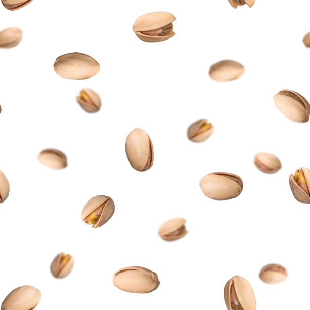 Seamless pattern with falling pistachio nuts isolated on white background. Levity kernels. stock photo