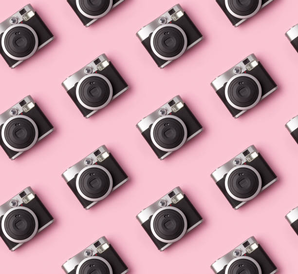 Seamless pattern with vintage instant camera at pastel pink background. stock photo