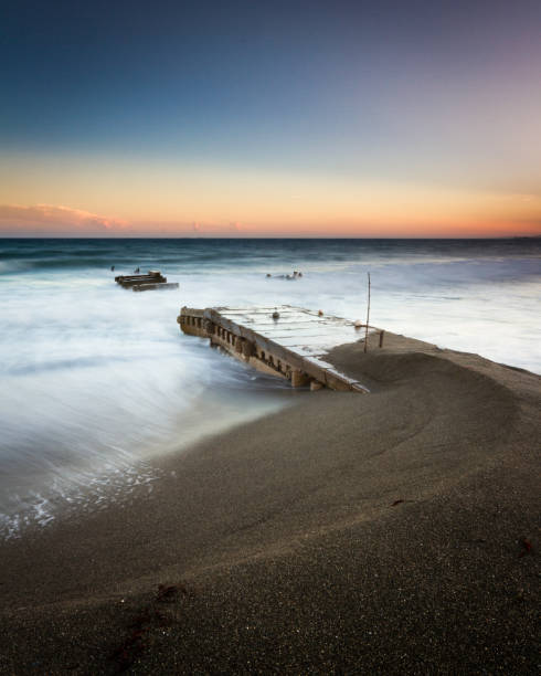 Seascape of an old pier at sunset stock photo