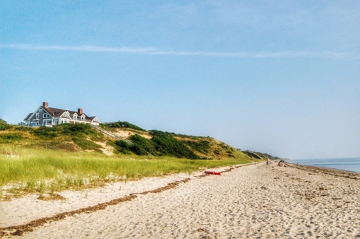 A seaside house sits on top of a sand dune. Clear blue skies in Truro, Massachusetts, USA