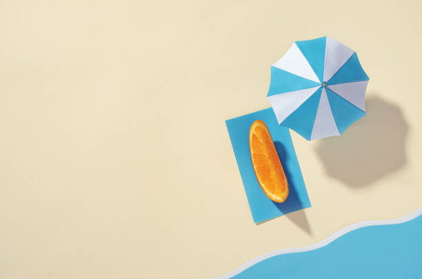 Seaside vacation concept - Aerial view of the beach with umbrella and orange stock photo