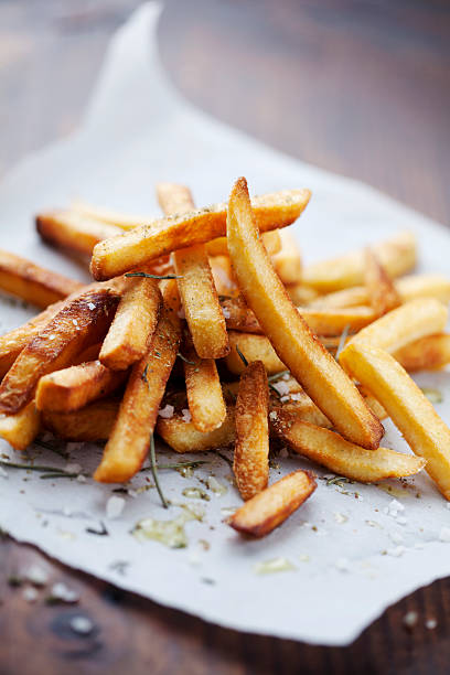 Seasoned french fries served on white butcher's parchment stock photo