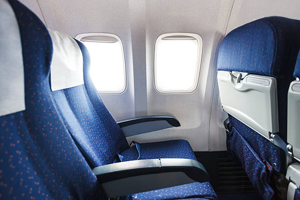 seats in economy class section of airplane blue seats in economy class passenger section of airplane airplane seat stock pictures, royalty-free photos & images
