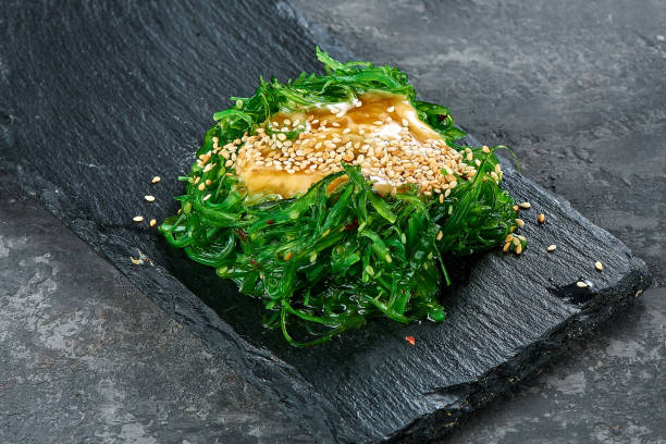 Seaweed salad in a black plate. Chuka wakame stock photo