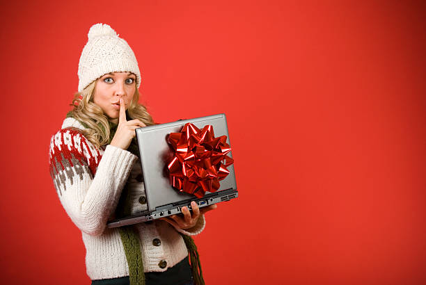 Secretive Woman With Laptop Computer For Christmas stock photo