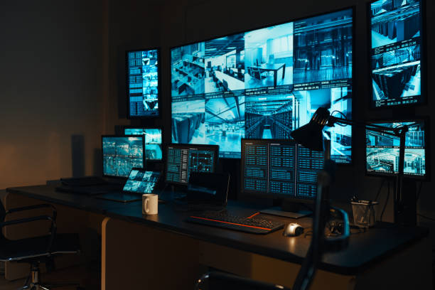 A security workplace with a modern high-tech control panel in the form of large monitors that display real-time information from external video surveillance cameras for 24 hours. stock photo