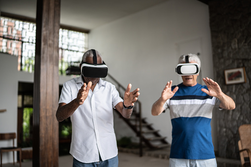 Seinor men using virtual reality glasses at home