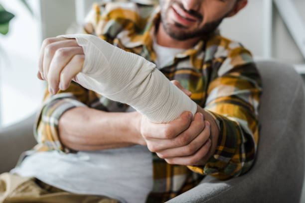 selective focus of injured arm of bearded man in bandage selective focus of injured arm of bearded man in bandage bone fracture stock pictures, royalty-free photos & images