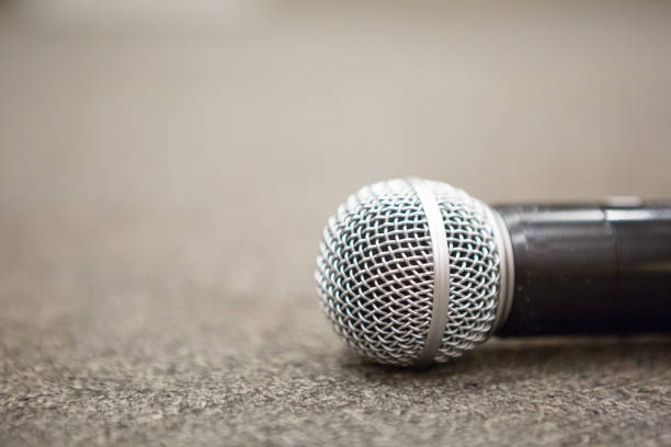Selective focus of Microphone on stage floor background stock photo