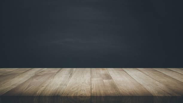 Selective focus of wood table top on blur dark blackboard background. stock photo