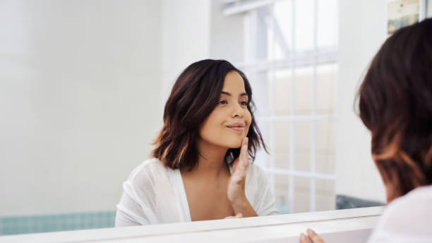 Self care, another form of love Shot of an attractive young woman going through her morning beauty routine in the bathroom vanity stock pictures, royalty-free photos & images
