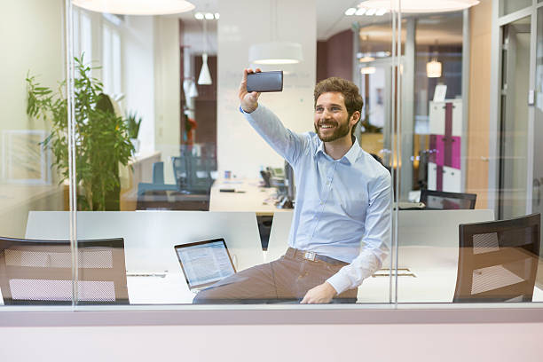 Selfie casual businessman taking pictures in open space office stock photo