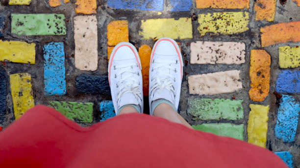 selfie di sneakers bianche e abito arancione su sfondo cemento o cemento, vista dall'alto. - floor top view foto e immagini stock