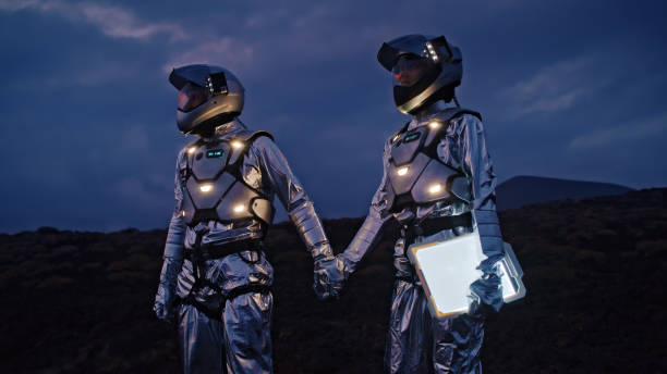 Selfie out of this world. Astronauts in futuristic, illuminated suits holding hands and taking a photo stock photo
