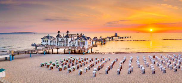 Sellin Pier at sunrise, Baltic Sea, Germany Famous Sellin Seebruecke (Sellin Pier) in beautiful golden morning light at sunrise in summer, Ostseebad Sellin tourist resort, Baltic Sea region, Germany sellin stock pictures, royalty-free photos & images