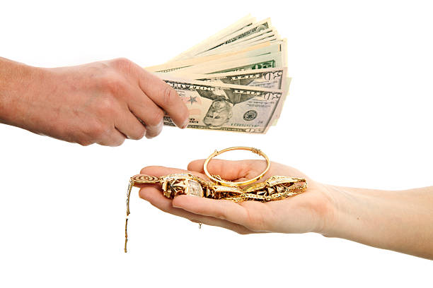 Selling gold for cash "Hand offers gold jewels, hand gives cash money." gold jewelry stock pictures, royalty-free photos & images
