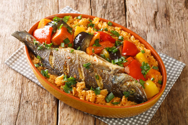 Senegalese food Thieboudienne cooked rice and fish with vegetables close-up in a dish. horizontal stock photo