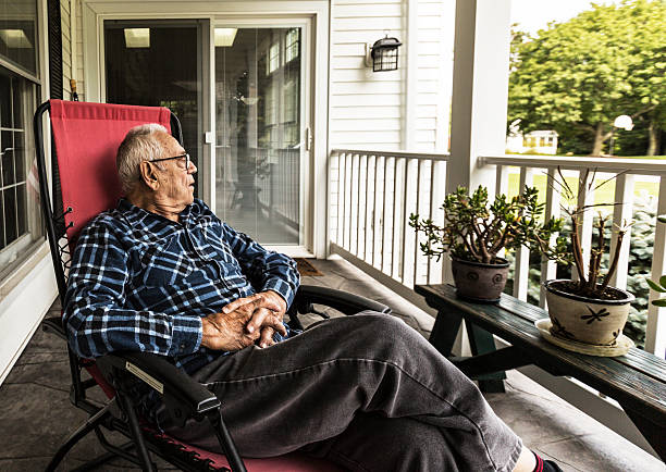 senior-adult-elderly-man-relaxing-on-front-porch-picture-id514179531